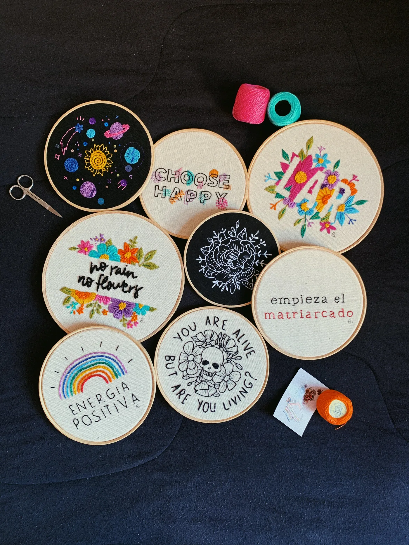 Bordados feitos à mão pela Bianca, com flores, planetas e frases coloridas